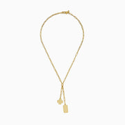 The 14K Yellow Gold Paperclip Dog Tag and Clover Lariat Necklace features elongated links with a four-leaf clover and rectangular tag charm side by side, crafted in 14K yellow gold and shown against a white background.