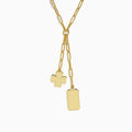 The 14K Yellow Gold Paperclip Dog Tag and Clover Lariat Necklace features elongated links with a four-leaf clover and rectangular tag charm side by side, crafted in 14K yellow gold and shown against a white background.