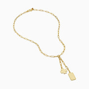 The 14K Yellow Gold Paperclip Dog Tag and Clover Lariat Necklace features elongated links with a four-leaf clover and rectangular tag charm side by side, crafted in 14K yellow gold and shown against a white background.
