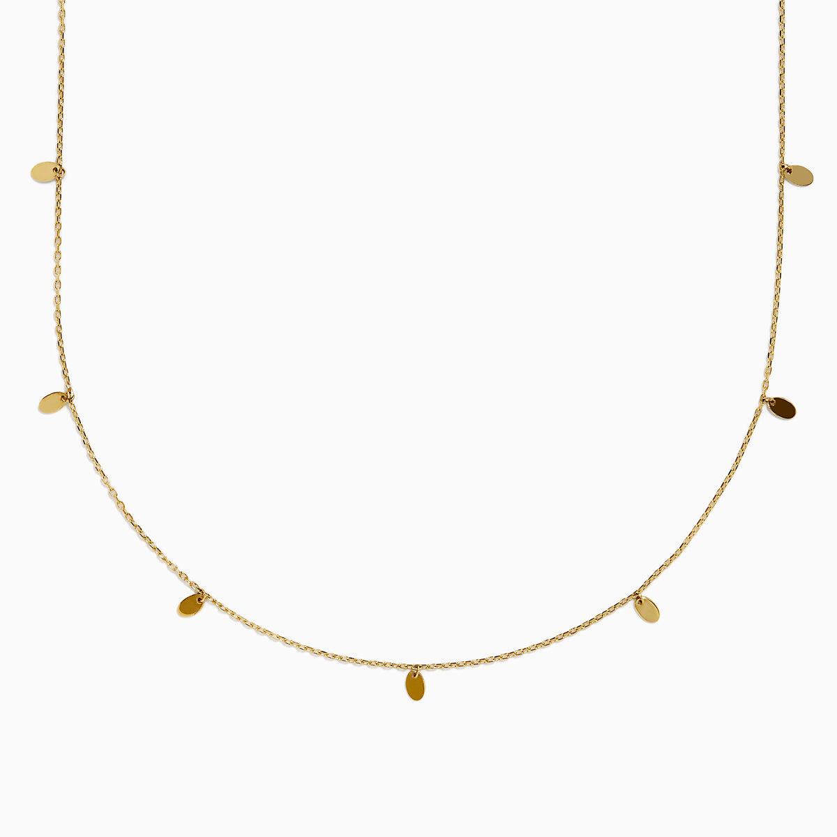 The 14K Yellow Gold Oval Charm Station Necklace features small, evenly spaced oval-shaped charms that hang gracefully along the lower half of a delicate yellow gold chain.