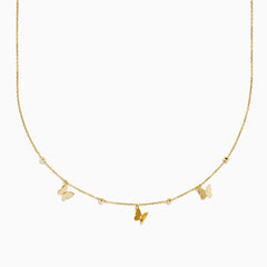 The 14K Yellow Gold Butterfly Station Necklace features three butterfly charms and four round beads evenly spaced along a delicate chain.