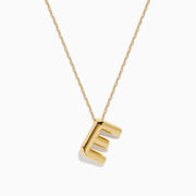 The 14K Yellow Gold Initial E Bubble Pendant sits on a thin chain, showcasing a bold, modern look against a plain white background.