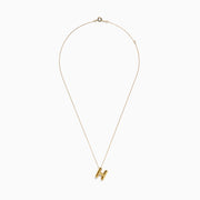 The 14K Yellow Gold Initial H Bubble Pendant features a delicate chain and a polished, shiny H pendant that stands out beautifully against any background.
