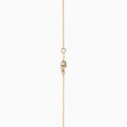 The 14K Yellow Gold Scattered Diamond Pendant features a teardrop-shaped diamond pendant partially encrusted with scattered diamonds, suspended from a delicate gold chain against a white background.