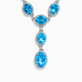 A close-up of the Ocean Bleu 14K White Gold Blue Topaz and Diamond Lavaliere Necklace featuring three oval blue topaz gemstones and diamonds in a vertical drop pendant, shown against a plain white background.