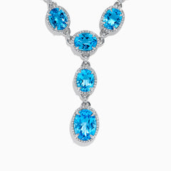 A close-up of the Ocean Bleu 14K White Gold Blue Topaz and Diamond Lavaliere Necklace featuring three oval blue topaz gemstones and diamonds in a vertical drop pendant, shown against a plain white background.