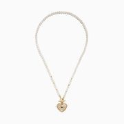 The 14K Yellow Gold Fresh Water Pearl Sapphire and Diamond Necklace features beaded pearls, a toggle clasp, and a heart-shaped gold pendant with an eye design set with diamonds and a central sapphire.