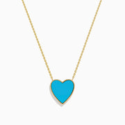 The 14K Gold Turquoise and Diamond Reversible Heart Necklace showcases a bold turquoise heart pendant framed in gold, displayed on a white background.