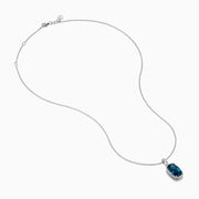 A 14 karat white gold necklace featuring an elongated cushion blue topaz and diamond pendant, set in an elegant frame.