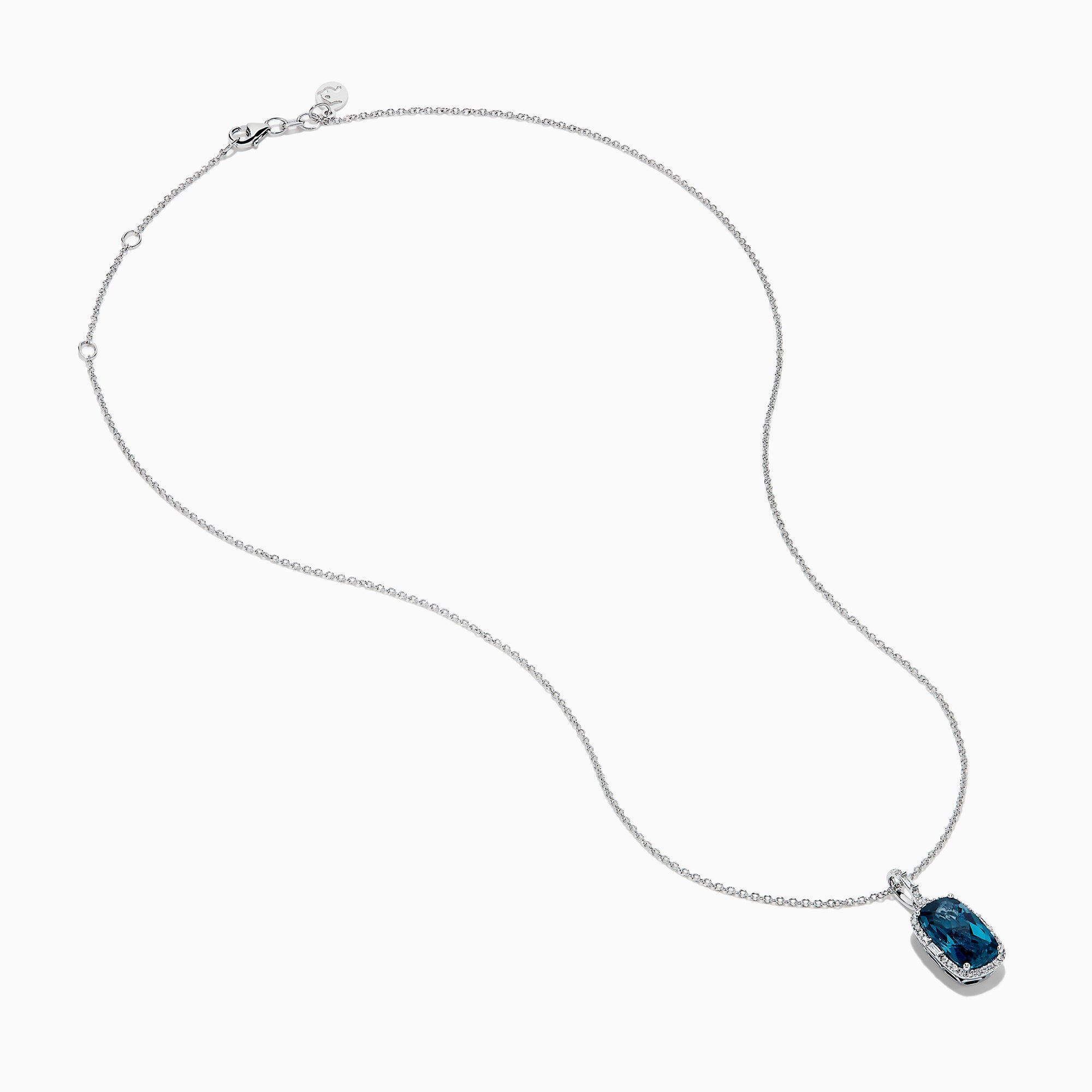 A 14 karat white gold necklace featuring an elongated cushion blue topaz and diamond pendant, set in an elegant frame.