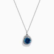 The Ocea Bleu 14K White Gold Blue Topaz and Diamond Pendant showcases a round blue topaz encircled by small diamonds, hanging from a delicate chain against a white background.