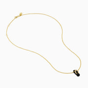 A delicate 14K yellow gold necklace features a flip flop pendant accented with onyx and diamonds, displayed against a white background.