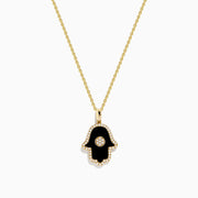 The Novelty 14K Yellow Gold Onyx and Diamond Hamsa Pendant features a black onyx hamsa hand accented with diamonds in a circular center design, shown on a yellow gold chain necklace against a white background.