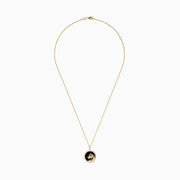 The Signature 14K Yellow Gold Onyx Emerald and Diamond Panther Pendant features a round onyx background, a detailed gold panther with an emerald green gemstone eye, and is surrounded by sparkling diamonds.
