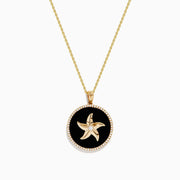 The Seaside 14K Yellow Gold Black Agate and Diamond Starfish Pendant features a gold starfish with a central gem on black agate, edged with sparkling diamonds and suspended from a yellow gold chain.