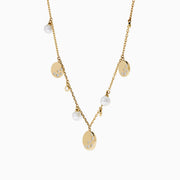The 14K Yellow Gold Pearl and Diamond Necklace features small round charms and lustrous pearls, with some charms adorned with sparkling diamonds, creating an elegant and delicate design against a white background.