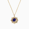 The 14K Yellow Gold Lapis and Diamond Celestial Sunburst Pendant features a blue lapis center, gold stars, a diamond-set crescent, and an elongated gold chain for an elegant celestial touch.