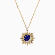 The 14K Yellow Gold Lapis and Diamond Celestial Sunburst Pendant features a blue lapis center, gold stars, a diamond-set crescent, and an elongated gold chain for an elegant celestial touch.