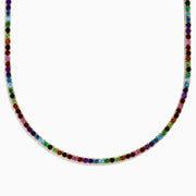 The 14K Yellow Gold Multi-Gemstone Rainbow Tennis Necklace features small, round gemstones spaced along its length and is shown on a white background.