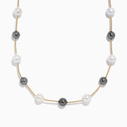 The 14K Yellow Gold Tahitian and Fresh Water Pearl Necklace features alternating black Tahitian pearls and white freshwater pearls, evenly spaced along a yellow gold chain and shown on a white background.