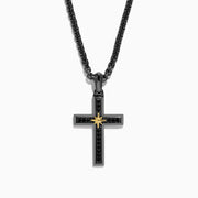 The Mens Rhodium Sterling Silver and Yellow Gold Plated Spinel Cross Pendant features a gold starburst center and hangs from a black chain, creating an elegant, striking look against a white background.