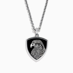 The Mens 925 Sterling Silver Onyx Pendant features a detailed engraved eagle head on a black shield-shaped background, crafted from sterling silver and suspended from a sleek silver chain.