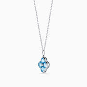 The Ocean Bleu 14K White Gold Blue Topaz and Diamond Pendant features a delicate chain and a four-petal flower blue topaz pendant accented with sparkling gemstones and a central diamond, set against a white background.