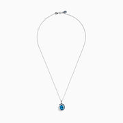 The Ocean Bleu 14K White Gold Pendant features a large blue topaz accented with swirling halos of blue and white diamonds, creating an elegant and eye-catching design.