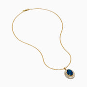 The 14K Yellow Gold London Blue Topaz and Diamond Double Halo Pendant features an oval London Blue Topaz and sparkling white diamonds, set on a gold chain necklace.