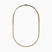 A close-up of the Canare 18K Two-Tone Gold Yellow and White Diamond Necklace features dual gemstone rows—one gold, one silver—in a curved U shape, highlighting its elegant two-tone design against a white background.