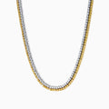 A close-up of the Canare 18K Two-Tone Gold Yellow and White Diamond Necklace features dual gemstone rows—one gold, one silver—in a curved U shape, highlighting its elegant two-tone design against a white background.