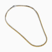 A close-up of the Canare 18K Two-Tone Gold Yellow and White Diamond Necklace features dual gemstone rows—one gold, one silver—in a curved U shape, highlighting its elegant two-tone design against a white background.