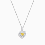 The 18K Two Tone Gold GIA Certified Yellow and White Diamond Heart Pendant features a radiant yellow center diamond surrounded by sparkling white diamonds, blending elegant charm with timeless beauty.