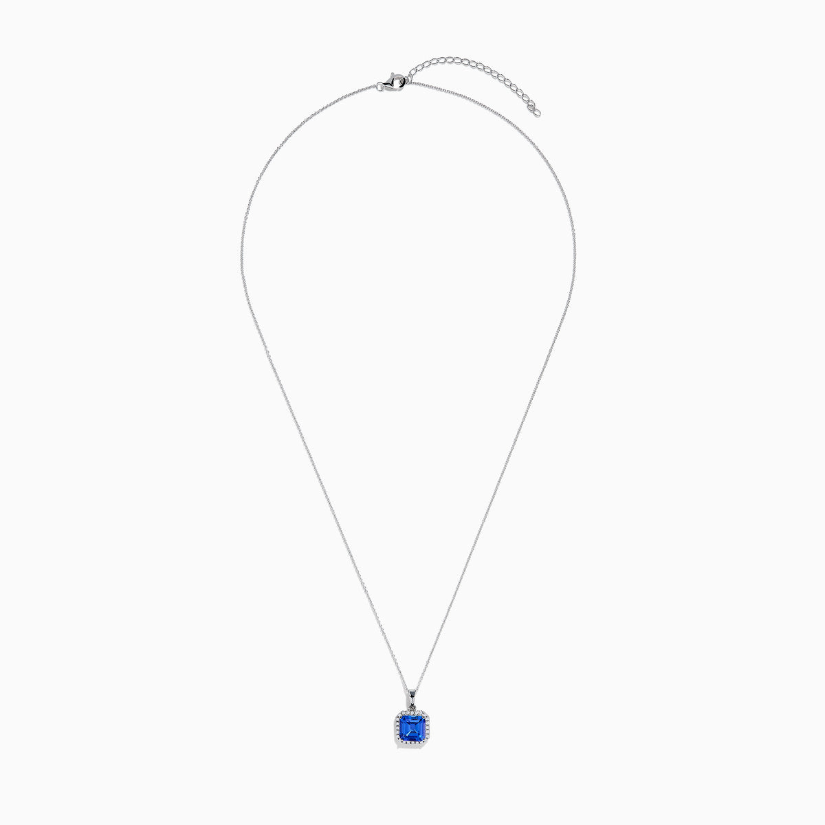The Nahla Siri 14K Gold Tanzanite and Diamond Pendant features a square blue tanzanite gemstone surrounded by sparkling diamonds, displayed against a white background.