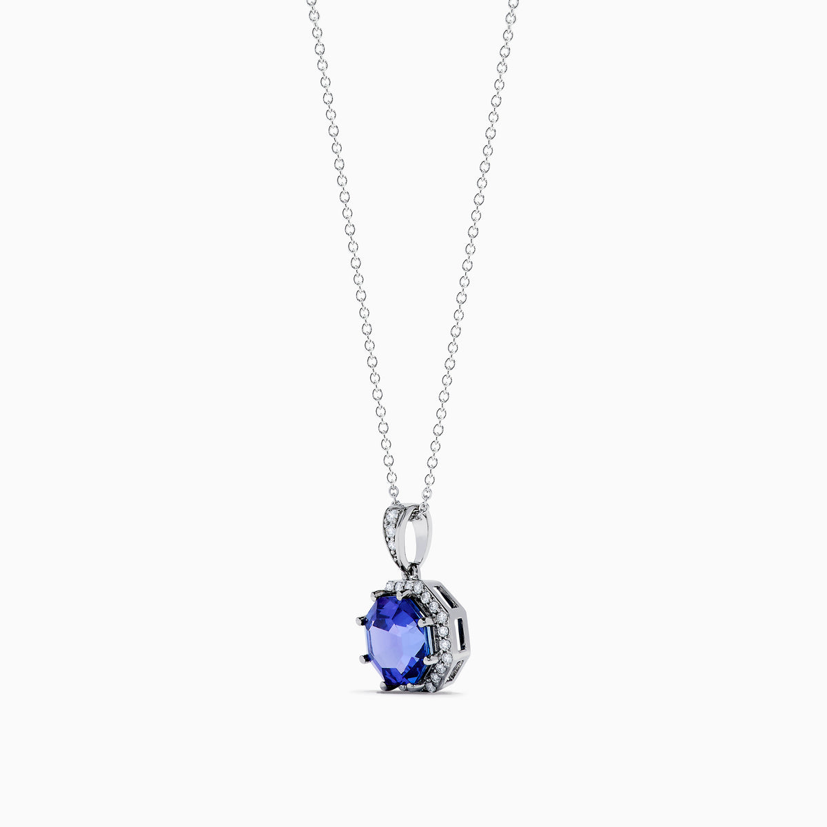 The Nahla Siri 14K Gold pendant showcases an octagon-cut tanzanite with a deep blue hue, surrounded by sparkling diamonds in a geometric setting.