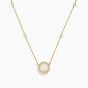 The Aurora 14K Yellow Gold Opal and Diamond Necklace features a round opal pendant encircled by diamonds, with extra diamond accents on the chain—an elegant accessory for any occasion.