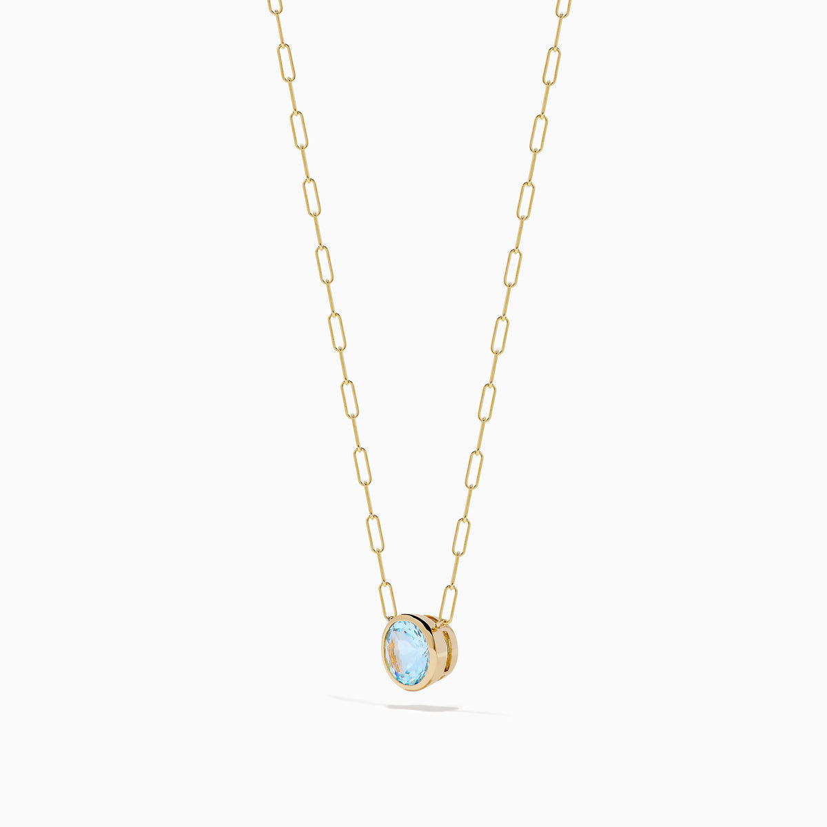 The 14K Yellow Gold Aquamarine Bezel Paperclip Chain Pendant features a round light blue aquamarine in a simple gold bezel on a delicate paperclip chain, shown against a white background.