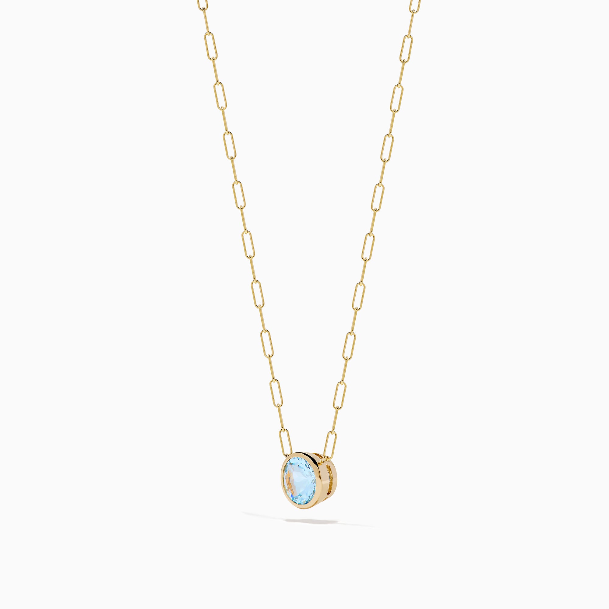 The 14K Yellow Gold Aquamarine Bezel Paperclip Chain Pendant features a round light blue aquamarine in a simple gold bezel on a delicate paperclip chain, shown against a white background.