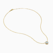 The 14K Yellow Gold Aquamarine Bezel Paperclip Chain Pendant features a round light blue aquamarine in a simple gold bezel on a delicate paperclip chain, shown against a white background.