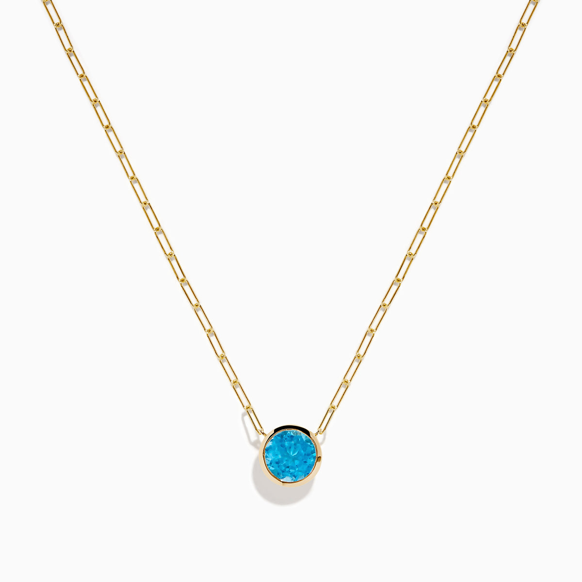 The 14K Yellow Gold Blue Topaz Bezel Paperclip Chain Pendant features a single round blue topaz gemstone on a gold paperclip chain, beautifully displayed against a white background.