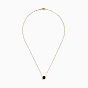 The 14K Yellow Gold Garnet Bezel Pendant with Paperclip Chain features a round dark red garnet in a simple gold bezel, showcased against a white background.