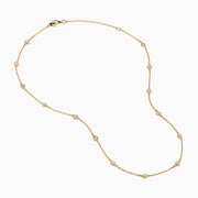The 14K Yellow Gold Diamond Station Necklace, 1.00 TCW, features evenly spaced round diamonds in bezel settings on a delicate gold chain, shown elegantly against a white background.
