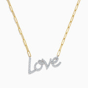 The 14K Two Tone Gold Diamond Love Necklace features a cursive love pendant adorned with sparkling diamond-clear stones.