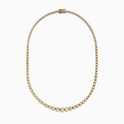 The 14K Yellow Gold Miracle Set Diamond Graduated Tennis Necklace showcases a single row of closely set, sparkling round diamonds in a gentle curve on yellow gold.