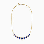 The Nahla 14K Yellow Gold Trillion Tanzanite and Diamond Necklace showcases seven deep blue trillion tanzanites, each framed by diamonds and evenly spaced along the chain.