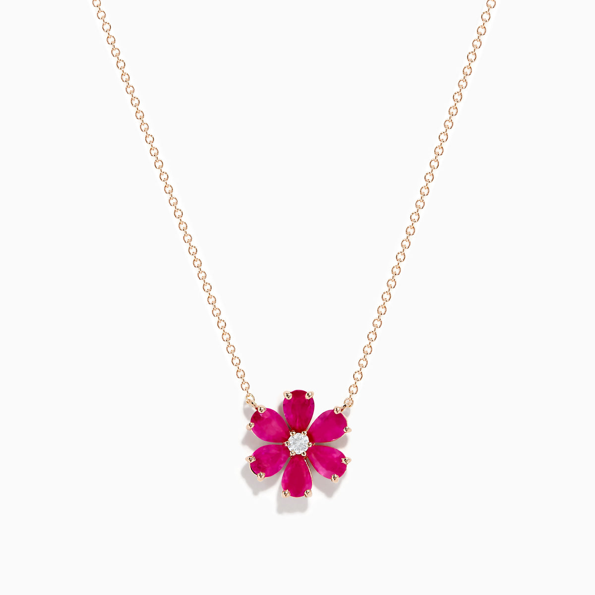 The 14K Rose Gold Ruby Flower Necklace features a pendant with six ruby gemstone petals and a small clear central stone.