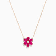 The 14K Rose Gold Ruby Flower Necklace features a pendant with six ruby gemstone petals and a small clear central stone.