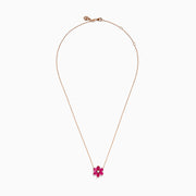 The 14K Rose Gold Ruby Flower Necklace features a pendant with six ruby gemstone petals and a small clear central stone.