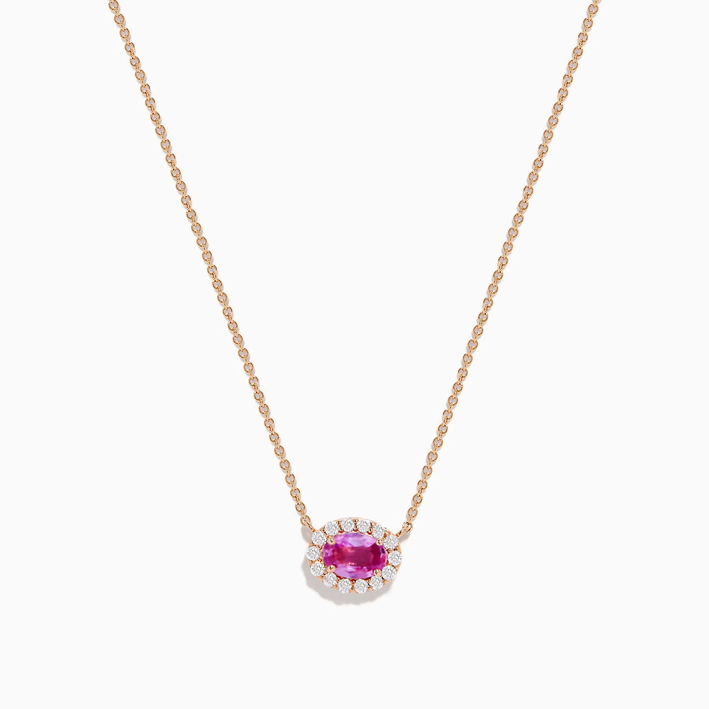 The 14K Rose Gold Pink Sapphire and Diamond Necklace features an oval pink sapphire pendant surrounded by a halo of white diamonds, elegantly displayed against a white background.