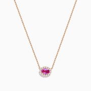 The 14K Rose Gold Pink Sapphire and Diamond Necklace features an oval pink sapphire pendant surrounded by a halo of white diamonds, elegantly displayed against a white background.